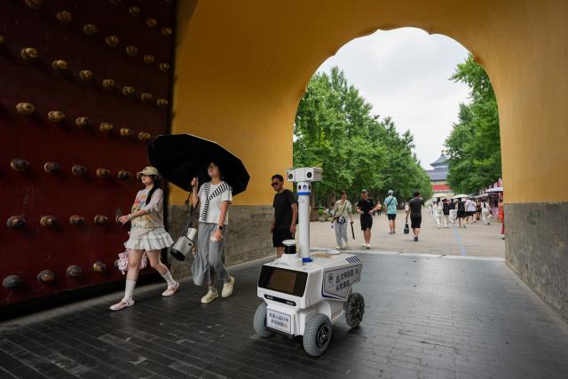 (260807) -- BEIJING, Aug. 7, 2026 (Xinhua) -- A robot patrols at the Temple of Heaven Park in Beijing, capital of China, Aug. 6, 2026.
  Fourteen municipal parks in Beijing have recently introduced a variety of new robots. These robots are now performing tasks such as cleaning, smart inspection, guided tours, water rescue, landscape maintenance, and ecological monitoring, bringing smart services into daily public life. (Xinhua/Ju Huanzong)