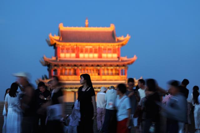 (260807) -- BEIJING, Aug. 7, 2026 (Xinhua) -- Visitors enjoy a night tour at the Jiayu Pass scenic area in the city of Jiayuguan, northwest China's Gansu Province, Aug. 5, 2026. (Xinhua/Chen Bin)