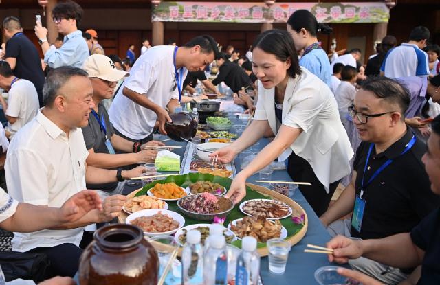 (260807) -- SANJIANG, Aug. 7, 2026 (Xinhua) -- Tourists enjoy a traditional "Hundred-Family Banquet" in Sanjiang Dong Autonomous County, south China's Guangxi Zhuang Autonomous Region, Aug. 6, 2026. A promotional event for tour operators was held here on Thursday, showcasing the region's ethnic culture and tourism resources through performances, a traditional "Hundred-Family Banquet" and other activities. (Xinhua/Lu Boan)
