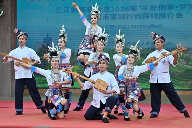 (260807) -- SANJIANG, Aug. 7, 2026 (Xinhua) -- Actors and actresses stage a performance during a promotional event in Sanjiang Dong Autonomous County, south China's Guangxi Zhuang Autonomous Region, Aug. 6, 2026. A promotional event for tour operators was held here on Thursday, showcasing the region's ethnic culture and tourism resources through performances, a traditional "Hundred-Family Banquet" and other activities. (Xinhua/Lu Boan)