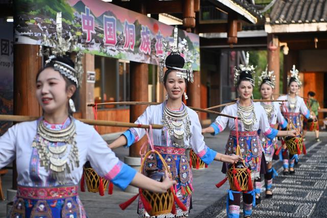 (260807) -- SANJIANG, Aug. 7, 2026 (Xinhua) -- Actresses stage a performance during a promotional event in Sanjiang Dong Autonomous County, south China's Guangxi Zhuang Autonomous Region, Aug. 6, 2026. A promotional event for tour operators was held here on Thursday, showcasing the region's ethnic culture and tourism resources through performances, a traditional "Hundred-Family Banquet" and other activities. (Xinhua/Lu Boan)