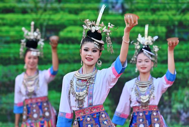 (260807) -- SANJIANG, Aug. 7, 2026 (Xinhua) -- Actresses stage a performance during a promotional event in Sanjiang Dong Autonomous County, south China's Guangxi Zhuang Autonomous Region, Aug. 6, 2026. A promotional event for tour operators was held here on Thursday, showcasing the region's ethnic culture and tourism resources through performances, a traditional "Hundred-Family Banquet" and other activities. (Xinhua/Lu Boan)