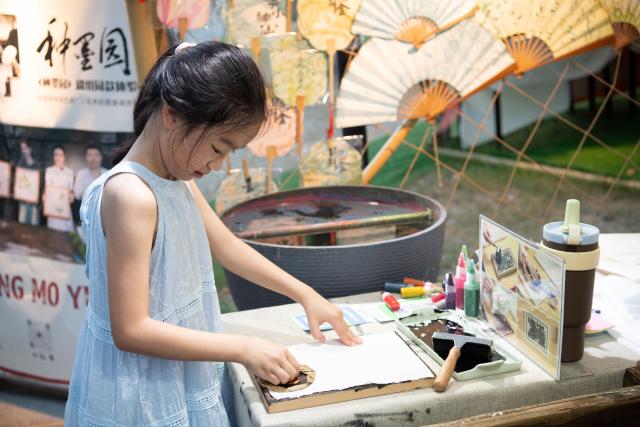 (260807) -- HEFEI, Aug. 7, 2026 (Xinhua) -- A child experiences traditional rubbing craft at a cultural market at Huiyuan Garden scenic area in Hefei, east China's Anhui Province, on July 31, 2026. Recently, the city of Hefei in east China has held a series of themed markets which took advantage of local cultural and tourism resources to boost consumption.
   At Huiyuan Garden scenic area, a cultural market featuring creative products, folk songs and performances, fish-shaped lantern parades and local delicacies offers visitors an immersive experience of Anhui culture.
   In Dawei Town, a grape-themed market provides a platform for local farmers to promote agricultural products. Visitors can taste various varieties of grapes and grape-based drinks, purchase agricultural products with discounts, and participate in study tours.
   By integrating cultural experiences, leisure activities and consumption, these themed markets have succeeded in attracting visitors while creating new opportunities for local tourism and rural industries. (Xinhua/Zhang Duan)