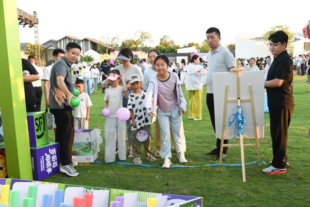 (260807) -- HEFEI, Aug. 7, 2026 (Xinhua) -- Children participate in a game session at a grape-themed market in Dawei Town of Hefei, east China's Anhui Province, on July 31, 2026. Recently, the city of Hefei in east China has held a series of themed markets which took advantage of local cultural and tourism resources to boost consumption.
   At Huiyuan Garden scenic area, a cultural market featuring creative products, folk songs and performances, fish-shaped lantern parades and local delicacies offers visitors an immersive experience of Anhui culture.
   In Dawei Town, a grape-themed market provides a platform for local farmers to promote agricultural products. Visitors can taste various varieties of grapes and grape-based drinks, purchase agricultural products with discounts, and participate in study tours.
   By integrating cultural experiences, leisure activities and consumption, these themed markets have succeeded in attracting visitors while creating new opportunities for local tourism and rural industries. (Photo by Ye Yuting/Xinhua)
