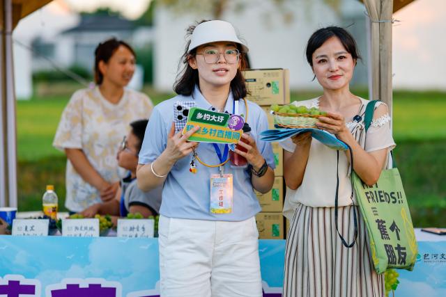 (260807) -- HEFEI, Aug. 7, 2026 (Xinhua) -- A staff member (L, front) promotes grapes via live streaming at a grape-themed market in Dawei Town of Hefei, east China's Anhui Province, on July 31, 2026. Recently, the city of Hefei in east China has held a series of themed markets which took advantage of local cultural and tourism resources to boost consumption.
   At Huiyuan Garden scenic area, a cultural market featuring creative products, folk songs and performances, fish-shaped lantern parades and local delicacies offers visitors an immersive experience of Anhui culture.
   In Dawei Town, a grape-themed market provides a platform for local farmers to promote agricultural products. Visitors can taste various varieties of grapes and grape-based drinks, purchase agricultural products with discounts, and participate in study tours.
   By integrating cultural experiences, leisure activities and consumption, these themed markets have succeeded in attracting visitors while creating new opportunities for local tourism and rural industries. (Photo by Fan Bowen/Xinhua)