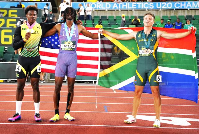 (260807) -- EUGENE, Aug. 7, 2026 (Xinhua) -- Gold medalist Tate Taylor (C) of the United States, silver medalist Gary Card (L) of Jamaica and bronze medalist Marko Ferreira of South Africa pose for photos after the men's 100m final at the 2026 World U20 Athletics Championships in Eugene, Oregon, the United States, Aug. 6, 2026. (Xinhua/Wu Xiaoling)