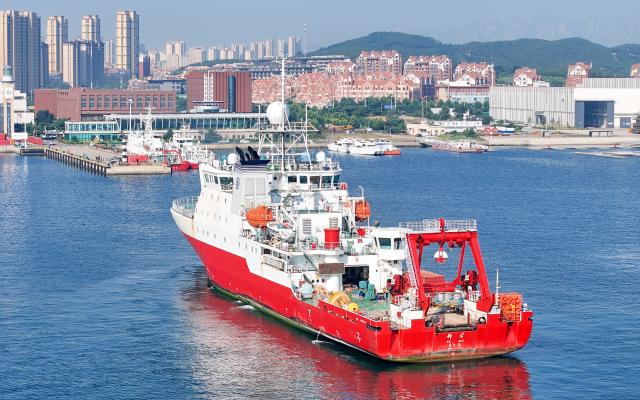 (260807) -- QINGDAO, Aug. 7, 2026 (Xinhua) -- A drone photo taken on Aug. 7, 2026 shows China's comprehensive research vessel KEXUE entering a wharf base in Qingdao, east China's Shandong Province. KEXUE docked at a wharf base of the Institute of Oceanology under the Chinese Academy of Sciences on Friday, marking the conclusion of a shared research cruise in the western Pacific after a 35-day voyage covering 5,845 nautical miles. The data and samples obtained during the cruise will provide scientific support for more accurate typhoon forecasting and global climate change research. (Photo by Zhang Jingang/Xinhua)