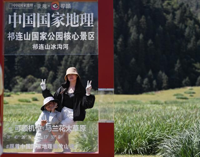(260807) -- WUWEI, Aug. 7, 2026 (Xinhua) -- Tourists pose for photos at the Binggouhe scenic spot in Tianzhu Tibetan Autonomous County of Wuwei City, northwest China's Gansu Province, Aug. 7, 2026. (Xinhua/Liu Keying)