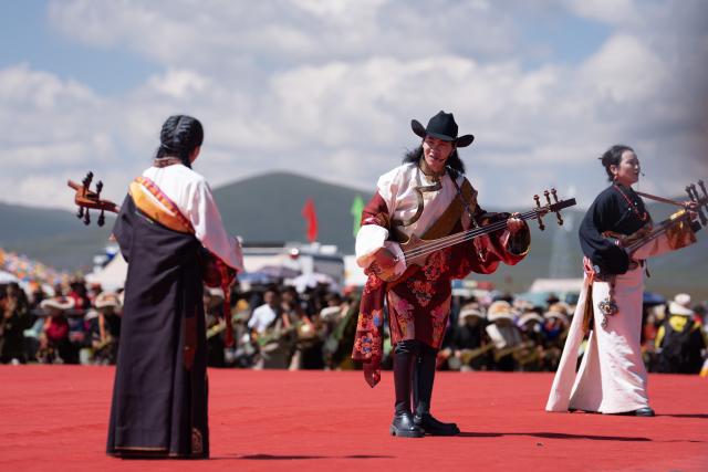 (260807) -- GARZE, Aug. 7, 2026 (Xinhua) -- Performers sing and play traditional instruments at the opening ceremony of the tent festival in Shiqu County of Garze Tibetan Autonomous Prefecture, southwest China's Sichuan Province, Aug. 7, 2026. A tent festival kicked off here on Friday. During the festival, local residents and tourists gather together, setting up tents and enjoying activities including horse racing, singing and dancing performances, and traditional sports competitions. (Xinhua/Jiang Hongjing)