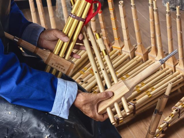 (260807) -- GUIYANG, Aug. 7, 2026 (Xinhua) -- Luo Tingkai, an inheritor of the craft of making the Miao Lusheng, introduces Lusheng at a workshop in Gaopo Township of Guiyang, southwest China's Guizhou Province, July 11, 2026. TO GO WITH "Across China: Centuries-old ethnic musical instrument finds new guardians in rural southwest China" (Xinhua)