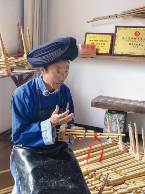(260807) -- GUIYANG, Aug. 7, 2026 (Xinhua) -- Luo Tingkai, an inheritor of the craft of making the Miao Lusheng, introduces Lusheng at a workshop in Gaopo Township of Guiyang, southwest China's Guizhou Province, July 11, 2026. TO GO WITH "Across China: Centuries-old ethnic musical instrument finds new guardians in rural southwest China" (Xinhua)