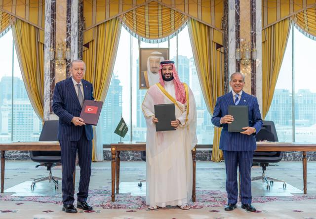 (260807) -- MAKKAH, Aug. 7, 2026 (Xinhua) -- Saudi Crown Prince and Prime Minister Mohammed bin Salman bin Abdulaziz Al Saud (C), Turkish President Recep Tayyip Erdogan (L) and Pakistani Prime Minister Muhammad Shehbaz Sharif pose for a group photo after signing the Makkah Joint Defense Agreement in Makkah, Saudi Arabia, on Aug. 7, 2026. TO GO WITH "Saudi Arabia, Türkiye, Pakistan sign joint defense agreement" (Saudi Press Agency/Handout via Xinhua)