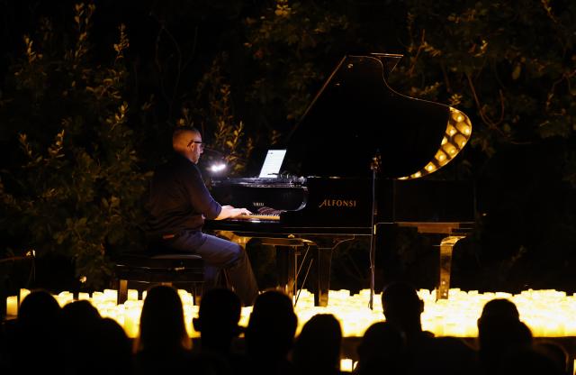 (260808) -- ROME, Aug. 8, 2026 (Xinhua) -- A pianist performs during the Candlelight Open Air concert at Villa Appia Antica in Rome, Italy, Aug. 7, 2026. Candlelight Open Air concert is a series of live musical performances held at iconic venues, including historic buildings, theaters, and monuments, illuminated by thousands of candles that create an intimate and special atmosphere. (Xinhua/Wang Kaiyan)