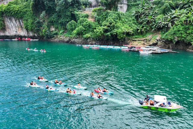 (260808) -- NANNING, Aug. 8, 2026 (Xinhua) -- An aerial drone photo taken on Aug. 5, 2026 shows people experiencing water sports in Tian'e County, south China's Guangxi Zhuang Autonomous Region. TO GO WITH "Letter from China: Paddleboarding boom in south China karst county" (Xinhua/Cao Yiming)