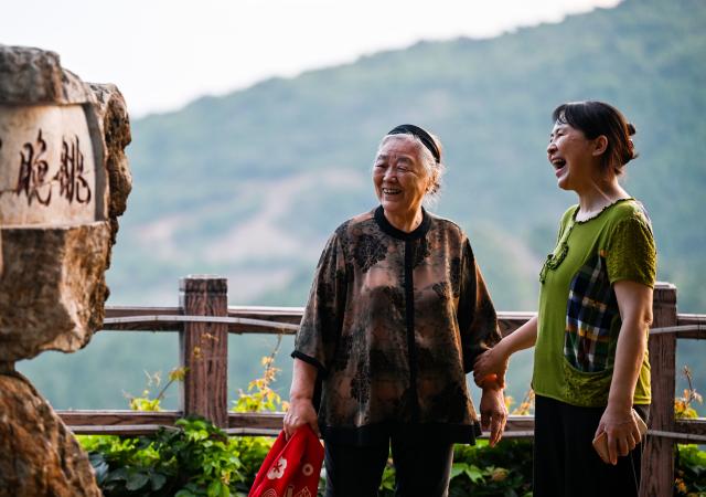 (260808) -- TIANJIN, Aug. 8, 2026 (Xinhua) -- Liu Anqin (L) and her daughter take a walk at Xijingyu Village of Jizhou District in north China's Tianjin, Aug. 4, 2026. Liu Anqin, 82, never expected that retirement would open a new chapter in her life.
   Born in northeast China's Heilongjiang Province, Liu had no formal training in painting. After retirement, she enrolled in painting classes at an education program for the elderly and discovered her passion for art. Six years ago, Liu moved to Tianjin with her son. This spring, she rented a courtyard in Xijingyu Village and opened a homestay. Inspired by the village's rustic charm and stony landscape, Liu began painting on stones.
   Unlike painting on paper, stone painting is more challenging and requires greater patience. Yet Liu enjoys the process. Just months later, the courtyard is no longer just a homestay; it has become a small art gallery that attracts visitors to take photos and appreciate stone paintings.
   For Liu, meeting new friends and sharing her passion for art with young people is always a delight. "It's never too late to start something new, as long as you enjoy it," she said. (Xinhua/Zhao Zishuo)