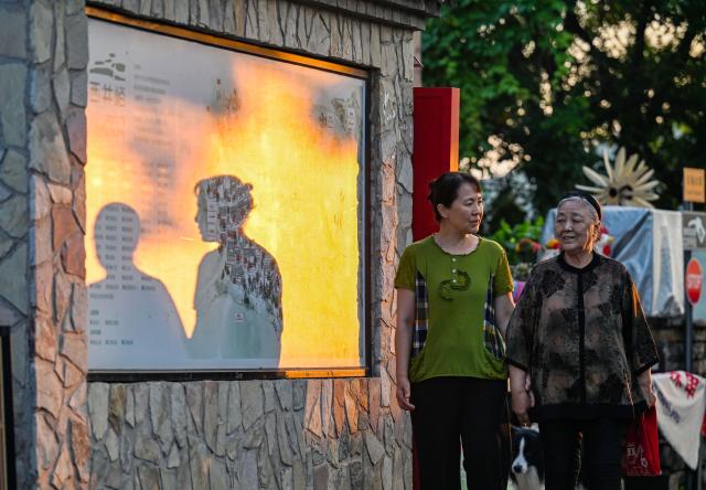 (260808) -- TIANJIN, Aug. 8, 2026 (Xinhua) -- Liu Anqin (R) and her daughter take a walk at Xijingyu Village of Jizhou District in north China's Tianjin, Aug. 4, 2026. Liu Anqin, 82, never expected that retirement would open a new chapter in her life.
   Born in northeast China's Heilongjiang Province, Liu had no formal training in painting. After retirement, she enrolled in painting classes at an education program for the elderly and discovered her passion for art. Six years ago, Liu moved to Tianjin with her son. This spring, she rented a courtyard in Xijingyu Village and opened a homestay. Inspired by the village's rustic charm and stony landscape, Liu began painting on stones.
   Unlike painting on paper, stone painting is more challenging and requires greater patience. Yet Liu enjoys the process. Just months later, the courtyard is no longer just a homestay; it has become a small art gallery that attracts visitors to take photos and appreciate stone paintings.
   For Liu, meeting new friends and sharing her passion for art with young people is always a delight. "It's never too late to start something new, as long as you enjoy it," she said. (Xinhua/Zhao Zishuo)