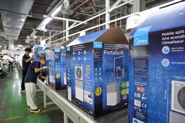 (260808) -- GUANGZHOU, Aug. 8, 2026 (Xinhua) -- Workers pack PortaSplit portable split air conditioners for the European market inside Midea's household air conditioner factory in Guangzhou, south China's Guangdong Province, Aug. 7, 2026. Demand for Chinese air conditioners has skyrocketed in many parts of Europe with heatwaves becoming more frequent, intense and prolonged this summer. PortaSplit, a portable split air conditioner from Chinese electronics manufacturer Midea, has become a hit product in the European market, with sales doubling compared to last year. Midea's household air conditioner factory in Guangzhou has ramped up production to meet international market demand. (Xinhua/Liang Xu)