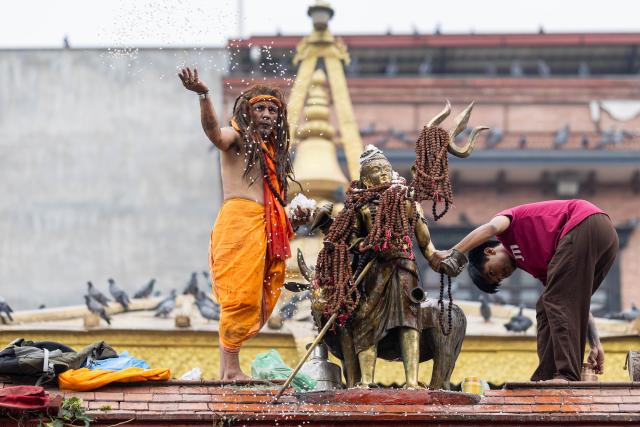 (260808) -- KATHMANDU, Aug. 8, 2026 (Xinhua) -- A priest (L) performs a ritual to mark the Hindu holy month of Shrawan in Kathmandu, Nepal, Aug. 8, 2026. (Photo by Sulav Shrestha/Xinhua)