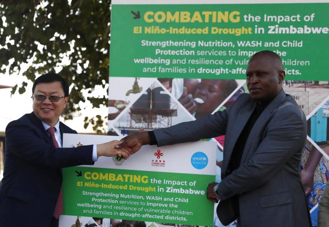 (260808) -- HARARE, Aug. 8, 2026 (Xinhua) -- Chinese Ambassador to Zimbabwe Zhou Ding (L) shakes hands with a Zimbabwean representative at the launch ceremony of a Chinese-funded program aimed at strengthening child support and recovery from the lingering effects of the 2023/24 El Nino-induced drought in Goromonzi District, Mashonaland East province, Zimbabwe, on Aug. 7, 2026. TO GO WITH "Zimbabwe launches Chinese-funded program to boost climate resilient services for children" (Photo by Shaun Jusa/Xinhua)