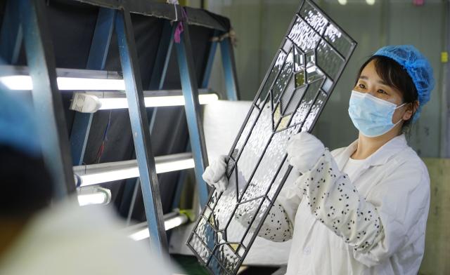 (260808) -- QINHUANGDAO, Aug. 8, 2026 (Xinhua) -- A worker examines glass products at a glass factory in Qinhuangdao, north China's Hebei Province, Aug. 8, 2026. The city is driving the transformation and upgrading in its glass manufacturing sector, with emphasis on products for artistic creation and other special purposes. (Photo by Yan Zhiguo/Xinhua)