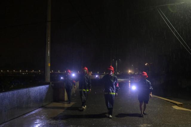(260808) -- WENZHOU, Aug. 8, 2026 (Xinhua) -- Volunteers patrol along the banks in Leqing, Wenzhou, east China's Zhejiang Province, Aug. 8, 2026. Coastal areas of eastern China were bracing for strong winds and torrential rain as Typhoon Dolphin approached, prompting authorities to recall fishing boats, suspend ferry services and prepare for evacuations.
   China's meteorological authority on Saturday upgraded its emergency response for Dolphin to Level III and raised the typhoon warning from yellow to orange. (Xinhua/Jiang Han)