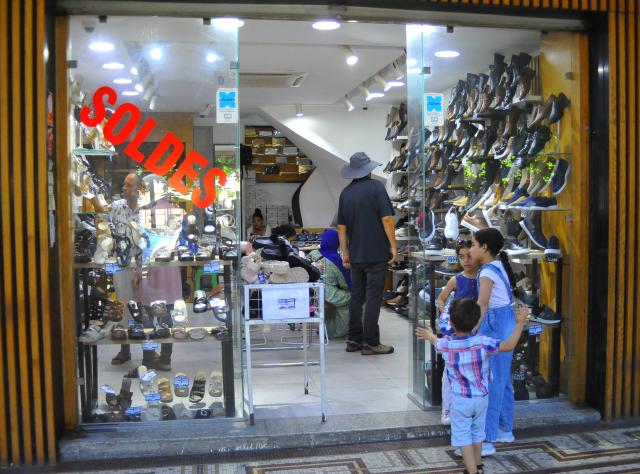 (260809) -- TUNIS, Aug. 9, 2026 (Xinhua) -- People shop at a store with sales advertisements in Tunis, Tunisia, Aug. 8, 2026. Tunisia launched its summer sales on Friday, which is expected to last six weeks. (Photo by Adel Ezzine/Xinhua)