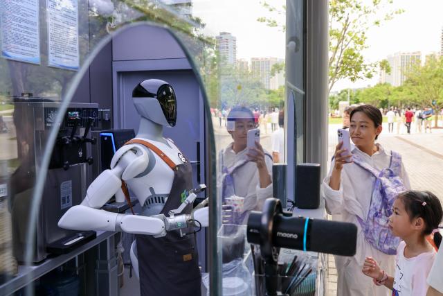 (260809) -- SHENZHEN, Aug. 9, 2026 (Xinhua) -- A humanoid robot makes ice cream for visitors at a park in Shenzhen, south China's Guangdong Province, Aug. 3, 2026. Humanoid robots are being deployed in a wide range of applications in Shenzhen, becoming increasing integrated into everyday work and life. (Xinhua/Liang Xu)
