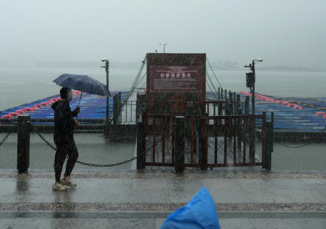 (260809) -- HANGZHOU, Aug. 9, 2026 (Xinhua) -- A visitor walks past a dock that is temporarily closed on the West Lake in Hangzhou, east China's Zhejiang Province, Aug. 9, 2026. China's national observatory on Sunday activated a red alert -- the highest level in the country's typhoon warning system -- as Typhoon Dolphin approaches.
  Typhoon Dolphin is forecast to make landfall along the country's east coast from Zhoushan in Zhejiang Province to Fuding in Fujian Province, according to the National Meteorological Center (NMC). (Xinhua/Han Chuanhao)