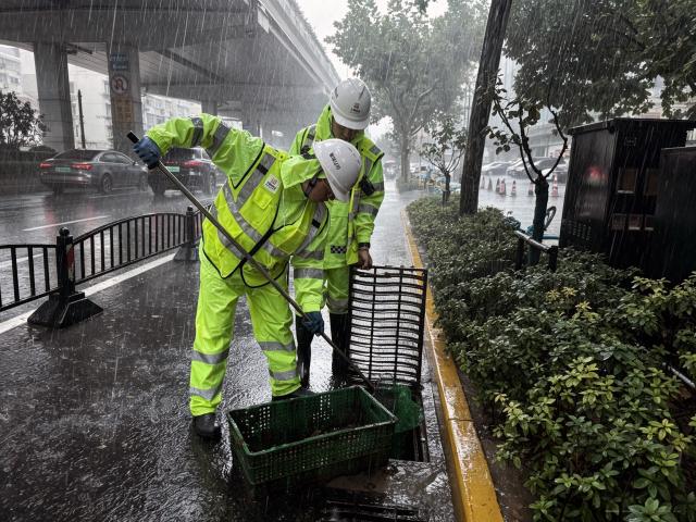 (260809) -- SHANGHAI, Aug. 9, 2026 (Xinhua) -- Workers clean a drain grate on a road in Xuhui District of Shanghai, east China, Aug. 9, 2026. Shanghai experienced strong winds and rainfalls on Sunday as Typhoon Dolphin approached, with the typhoon's impact expected to last until Aug. 11.
  China's national observatory on Sunday activated a red alert -- the highest level in the country's typhoon warning system -- as Typhoon Dolphin approaches.
  Typhoon Dolphin is forecast to make landfall along the country's east coast from Zhoushan in Zhejiang Province to Fuding in Fujian Province, according to the National Meteorological Center (NMC). (Photo by Wei Qingfeng/Xinhua)