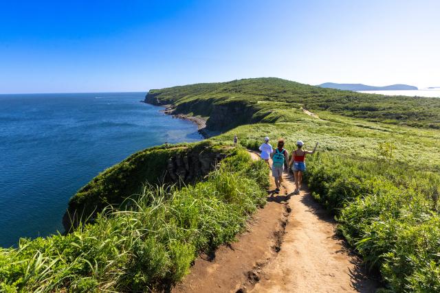 (260809) -- VLADIVOSTOK, Aug. 9, 2026 (Xinhua) -- People go hiking at Cape Tobizina in Vladivostok, Russia, Aug. 8, 2026. Located at the southernmost tip of Russky Island in Vladivostok, Cape Tobizina is a popular tourist destination. (Photo by Andrey Matveenko/Xinhua)