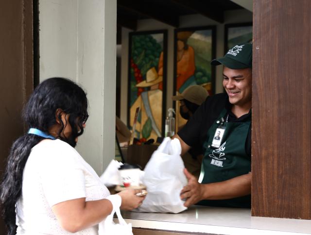 (260809) -- TEGUCIGALPA, Aug. 9, 2026 (Xinhua) -- A customer buys takeaway coffee in the old town of Tegucigalpa, Honduras, on Aug. 6, 2026. Tegucigalpa, the capital of Honduras, is the country's political and economic center. Surrounded by mountains and hills, the city is known for its hilly terrain, colorful streets and vibrant urban life. (Xinhua/Liu Wenhui)