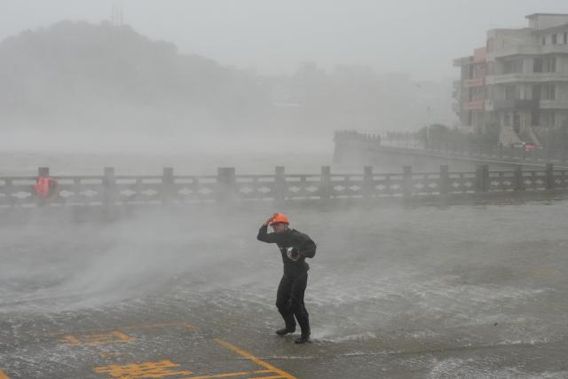 (260809) -- YUHUAN, Aug. 9, 2026 (Xinhua) -- A man is seen as Typhoon Dolphin makes landfall at Dongsha community in Yuhuan, Taizhou, east China's Zhejiang Province, Aug. 9, 2026. Typhoon Dolphin, the 13th typhoon of the year, made landfall at Yuhuan of Taizhou City, east China's Zhejiang Province, at around 5:30 p.m. on Sunday, said the National Meteorological Center (NMC).
  The maximum sustained wind near the typhoon center hit Force 14, or 42 meters per second, making Dolphin a severe typhoon upon landfall. (Xinhua/Huang Zongzhi)