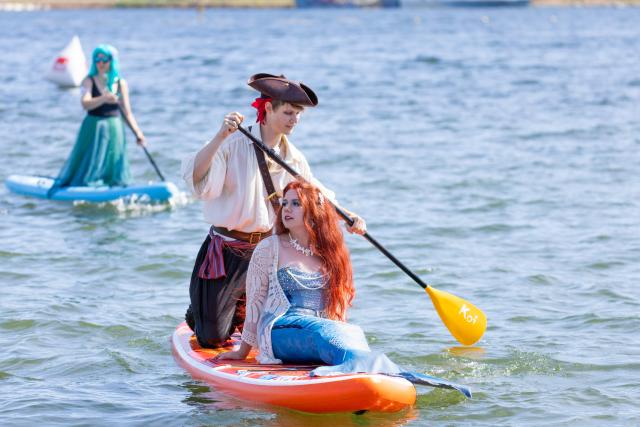 (260809) -- VLADIVOSTOK, Aug. 9, 2026 (Xinhua) -- People participate in a paddleboard carnival in Vladivostok, Russia, Aug. 9, 2026. The Vladivostok paddleboard carnival was held here on Sunday, with participants dressed as jellyfish, pirates, mermaids, and other characters. (Photo by Andrey Matveenko/Xinhua)