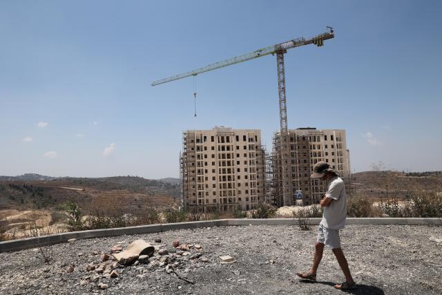 (260809) -- JERUSALEM, Aug. 9, 2026 (Xinhua) -- A man walks near the construction site of an Israeli settlement in the West Bank, near Jerusalem, Aug. 9, 2026. In recent years, Israel's continued approval of settlement expansions in the region has drawn widespread criticism from the international community. (Photo by Gil Cohen Magen/Xinhua)