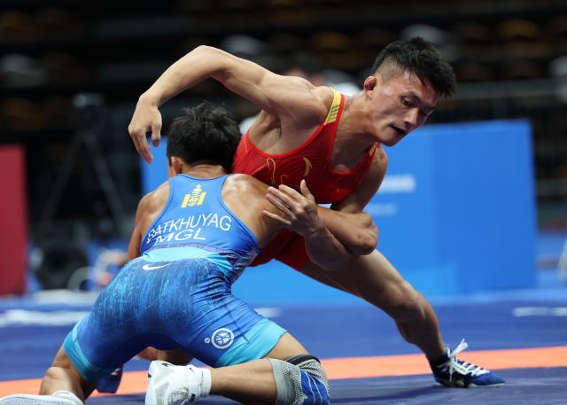 (260809) -- XI'AN, Aug. 9, 2026 (Xinhua) -- Munkh-erdene Batkhuyag (front) of Mongolia and Bai Jiliang of China compete during the men's freestyle 57kg final at 2026 China-Central Asia Elite Wrestling Tournament in Xi'an, northwest China's Shaanxi Province, Aug. 9, 2026. (Xinhua/Li Yibo)