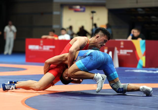(260809) -- XI'AN, Aug. 9, 2026 (Xinhua) -- Munkh-erdene Batkhuyag (R) of Mongolia and Bai Jiliang of China compete during the men's freestyle 57kg final at 2026 China-Central Asia Elite Wrestling Tournament in Xi'an, northwest China's Shaanxi Province, Aug. 9, 2026. (Xinhua/Li Yibo)