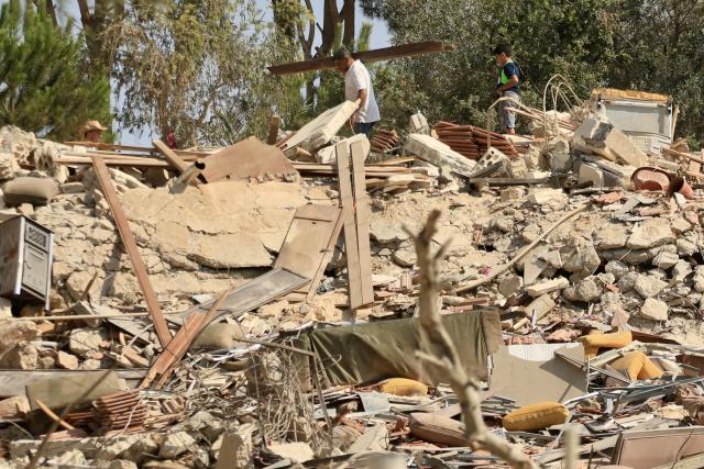 (260809) -- ZAWTAR AL-GHARBIYAH, Aug. 9, 2026 (Xinhua) -- This photo taken on Aug. 8, 2026 shows citizens removing debris from their destroyed homes following an Israeli advance into Zawtar al-Gharbiyah and the establishment of a sand barrier near a Lebanese Army position, in Zawtar al-Gharbiyah, southern Lebanon. (Photo by Ali Hashisho/Xinhua)