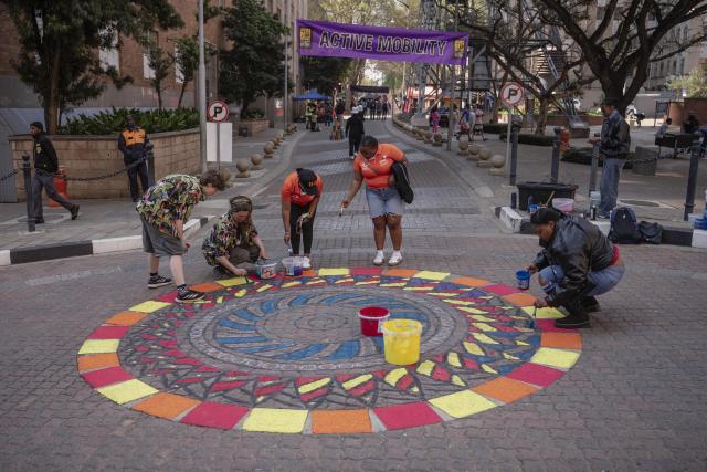 (260810) -- JOHANNESBURG, Aug. 10, 2026 (Xinhua) -- People paint graffiti on a street during a car-free event in Johannesburg, South Africa, Aug. 9, 2026. During the event, some streets in Johannesburg were turned into car-free zones from 10 a.m. to 5 p.m., with motor vehicles banned. (Photo by Ihsaan Haffejee/Xinhua)