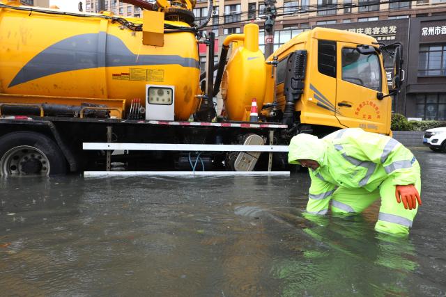 (260810) -- BEIJING, Aug. 10, 2026 (Xinhua) -- A rescue worker works on a waterlogged road in Changzhou, east China's Jiangsu Province, Aug. 10, 2026. Typhoon Dolphin is moving inland after making two landfalls along the coast of east China's Zhejiang Province and is expected to bring heavy precipitation to more than 10 provincial-level regions, according to China's National Meteorological Center on Monday.
   The center issued a blue typhoon warning on Monday morning, forecasting persistent heavy rainfall through Wednesday in regions including Zhejiang, Jiangsu, Henan and Hebei. Some areas are likely to experience torrential rain, thunderstorms and strong winds.
   Authorities in multiple localities have made all-out efforts in flood prevention and typhoon response. (Photo by Chen Wei/Xinhua)