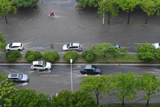 (260810) -- BEIJING, Aug. 10, 2026 (Xinhua) -- Vehicles drive through a waterlogged street in Wuxi, east China's Jiangsu Province, Aug. 10, 2026. Typhoon Dolphin is moving inland after making two landfalls along the coast of east China's Zhejiang Province and is expected to bring heavy precipitation to more than 10 provincial-level regions, according to China's National Meteorological Center on Monday.
   The center issued a blue typhoon warning on Monday morning, forecasting persistent heavy rainfall through Wednesday in regions including Zhejiang, Jiangsu, Henan and Hebei. Some areas are likely to experience torrential rain, thunderstorms and strong winds.
   Authorities in multiple localities have made all-out efforts in flood prevention and typhoon response. (Photo by Huan Yueliang/Xinhua)