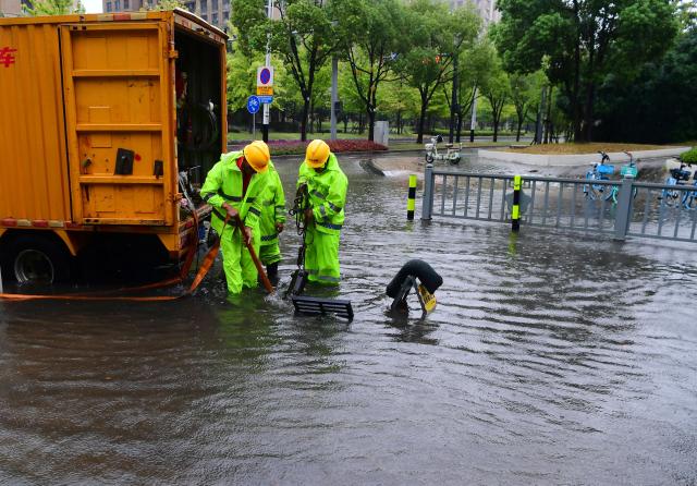 (260810) -- BEIJING, Aug. 10, 2026 (Xinhua) -- Workers drain water on a waterlogged road in Wuxi, east China's Jiangsu Province, Aug. 10, 2026. Typhoon Dolphin is moving inland after making two landfalls along the coast of east China's Zhejiang Province and is expected to bring heavy precipitation to more than 10 provincial-level regions, according to China's National Meteorological Center on Monday.
   The center issued a blue typhoon warning on Monday morning, forecasting persistent heavy rainfall through Wednesday in regions including Zhejiang, Jiangsu, Henan and Hebei. Some areas are likely to experience torrential rain, thunderstorms and strong winds.
   Authorities in multiple localities have made all-out efforts in flood prevention and typhoon response. (Photo by Huan Yueliang/Xinhua)