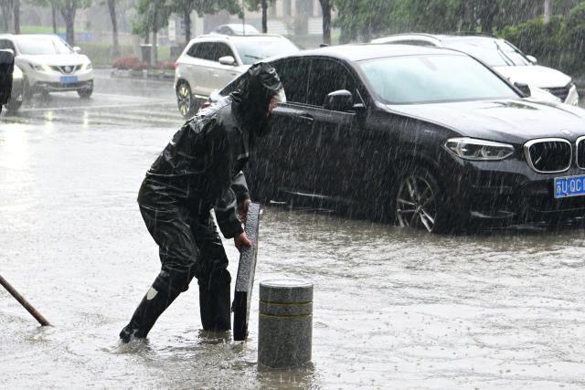 (260810) -- BEIJING, Aug. 10, 2026 (Xinhua) -- A worker unclogs a drain in Taicang, east China's Jiangsu Province, Aug. 10, 2026. Typhoon Dolphin is moving inland after making two landfalls along the coast of east China's Zhejiang Province and is expected to bring heavy precipitation to more than 10 provincial-level regions, according to China's National Meteorological Center on Monday.
   The center issued a blue typhoon warning on Monday morning, forecasting persistent heavy rainfall through Wednesday in regions including Zhejiang, Jiangsu, Henan and Hebei. Some areas are likely to experience torrential rain, thunderstorms and strong winds.
   Authorities in multiple localities have made all-out efforts in flood prevention and typhoon response. (Photo by Ji Haixin/Xinhua)