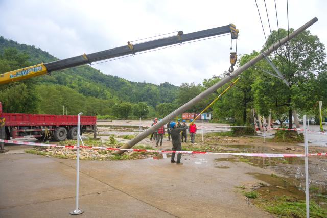 (260810) -- WENZHOU, Aug. 10, 2026 (Xinhua) -- Electrical workers carry out emergency repairs on a fallen utility pole toppled by Typhoon Dolphin in Lianfeng Village in Wenzhou, east China's Zhejiang Province, Aug. 10, 2026. Typhoon Dolphin is moving inland after making two landfalls along the coast of east China's Zhejiang Province and is expected to bring heavy precipitation to more than 10 provincial-level regions, according to China's National Meteorological Center on Monday. (Xinhua/Jiang Han)