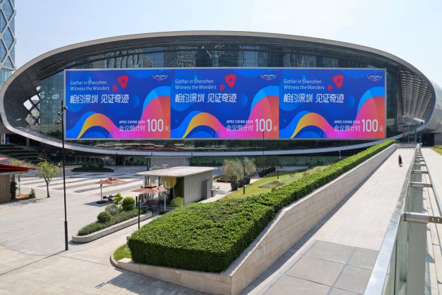 (260810) -- SHENZHEN, Aug. 10, 2026 (Xinhua) -- This photo taken on Aug. 10, 2026 shows a view of the Shenzhen Bay Sports Center, with a bulletin board indicating the 100-day countdown to the 33rd Asia-Pacific Economic Cooperation (APEC) Economic Leaders' Meeting, in Shenzhen, south China's Guangdong Province. With themed bulletin boards, outdoor posts, decorations and installations, Shenzhen marked on Monday the 100-day countdown to the 33rd Asia-Pacific Economic Cooperation (APEC) Economic Leaders' Meeting. (Xinhua/Liang Xu)