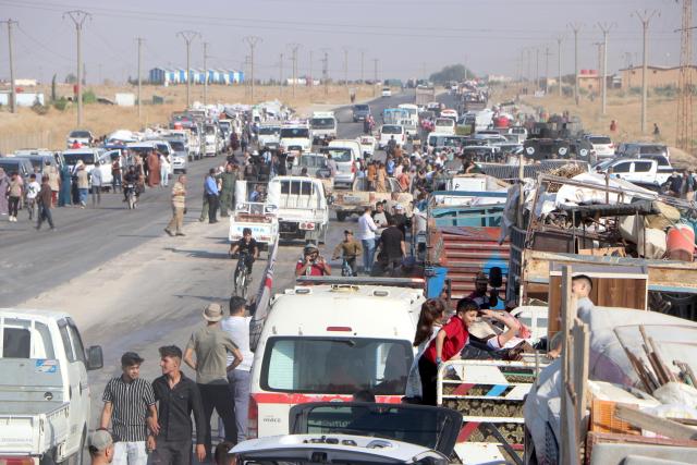 (260810) -- HASAKAH, Aug. 10, 2026 (Xinhua) -- Vehicles carrying displaced Syrian families and their belongings gather before departing for the city of Ras al-Ain and its surrounding villages in Hasakah province, northeastern Syria, Aug. 10, 2026. More than 400 Syrian families returned to the city of Ras al-Ain in northeastern Hasakah province and its surrounding villages on Monday, marking the first organized convoy of displaced residents heading home in that area after nearly seven years of displacement. (Str/Xinhua)