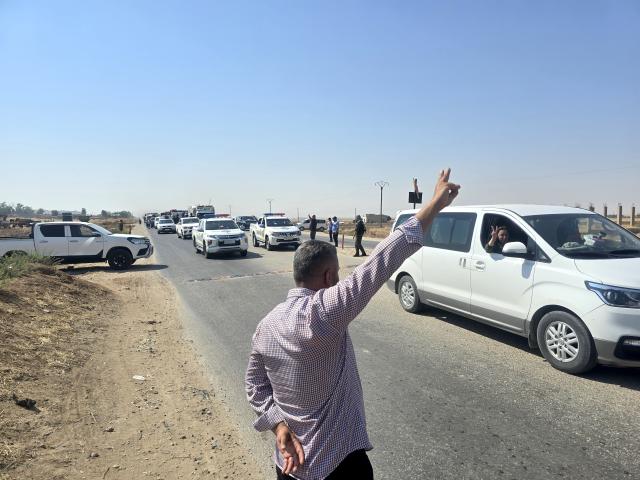 (260810) -- HASAKAH, Aug. 10, 2026 (Xinhua) -- A man waves as a convoy carrying displaced Syrian families heads toward the city of Ras al-Ain and its surrounding villages in Hasakah province, northeastern Syria, Aug. 10, 2026. More than 400 Syrian families returned to the city of Ras al-Ain in northeastern Hasakah province and its surrounding villages on Monday, marking the first organized convoy of displaced residents heading home in that area after nearly seven years of displacement. (Str/Xinhua)