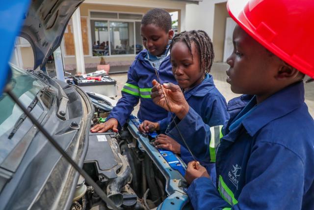 (260811) -- DAR ES SALAAM, Aug. 11, 2026 (Xinhua) -- Students gather to inspect a car during a practical skills class at De'kayra Pre and Primary School in Bagamoyo, Tanzania, Aug. 7, 2026. TO GO WITH "Feature: Learning by doing prepares Tanzanian children for future" (Xinhua/Emmanuel Herman)