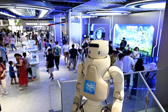 (260811) -- QINGDAO, Aug. 11, 2026 (Xinhua) -- People visit a robot 6S experience store in Qingdao, east China's Shandong Province on Aug. 11, 2026. Recently, the first robot 6S experience store in Qingdao opened, attracting a large number of consumers to visit and experience. This store integrates six major functions including sale, spare parts, service, survey, lease and personalized customization, helping further introducing robots into people's lives. (Xinhua/Li Ziheng)