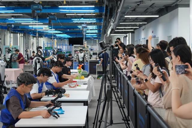 (260811) -- BEIJING, Aug. 11, 2026 (Xinhua) -- Journalists visit a humanoid robot data training center in Shijingshan District of Beijing, capital of China, Aug. 10, 2026. A press conference and a series of promotional events for the 2026 China International Fair for Trade in Services (CIFTIS) were held at Shougang Park in Beijing on Monday. The fair is going to be staged in Beijing from Sept. 9 to 13. (Xinhua/Xie Han)