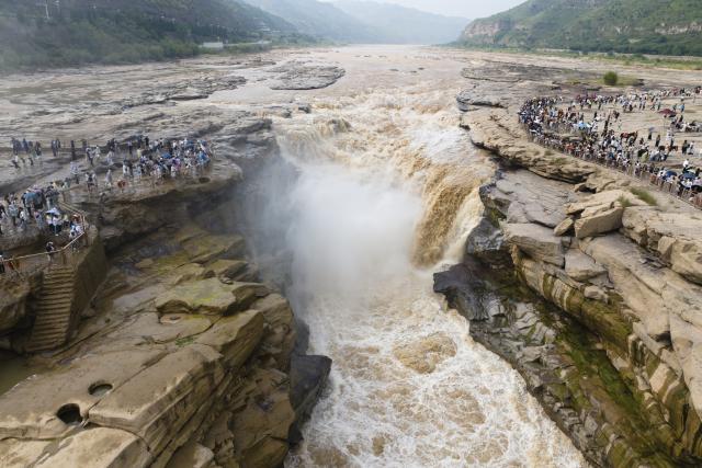 (260811) -- XI'AN, Aug. 11, 2026 (Xinhua) -- An aerial drone photo taken on Aug. 10, 2026 shows tourists visiting the Yellow River's Hukou Waterfall in northwest China's Shaanxi Province. (Xinhua/Shao Rui)